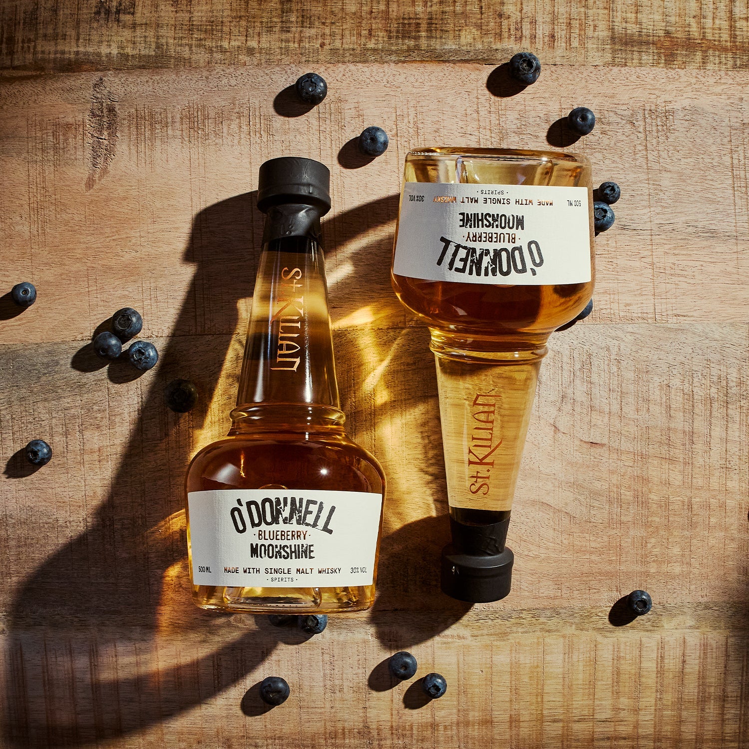 O'Donnell & St.Kilian Blueberry Moonshine Flasche umgeben von Blaubeeren