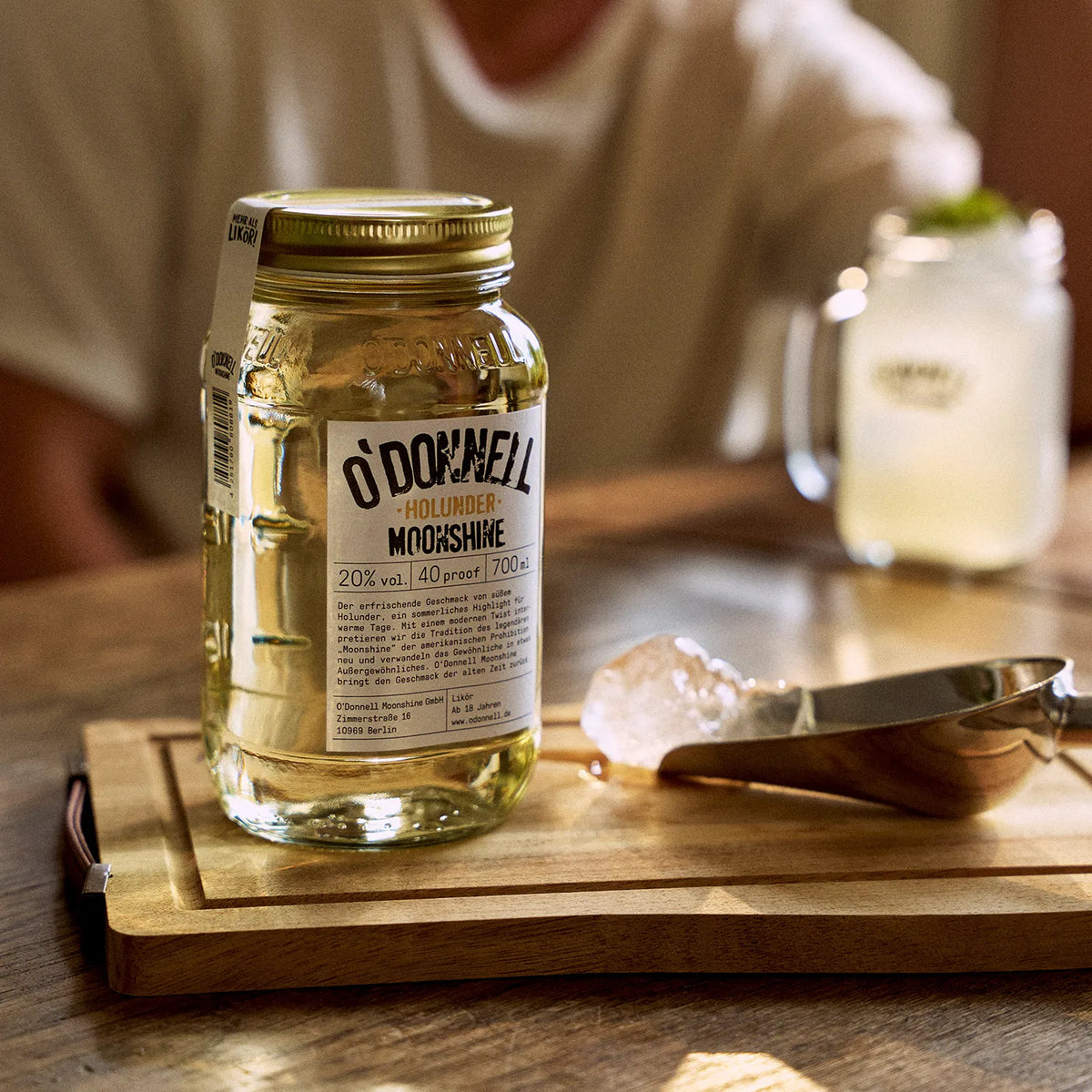 O'Donnell Moonshine Holunder-Likör mit einem Mason Jar vor einem angerichteten Cocktail.
