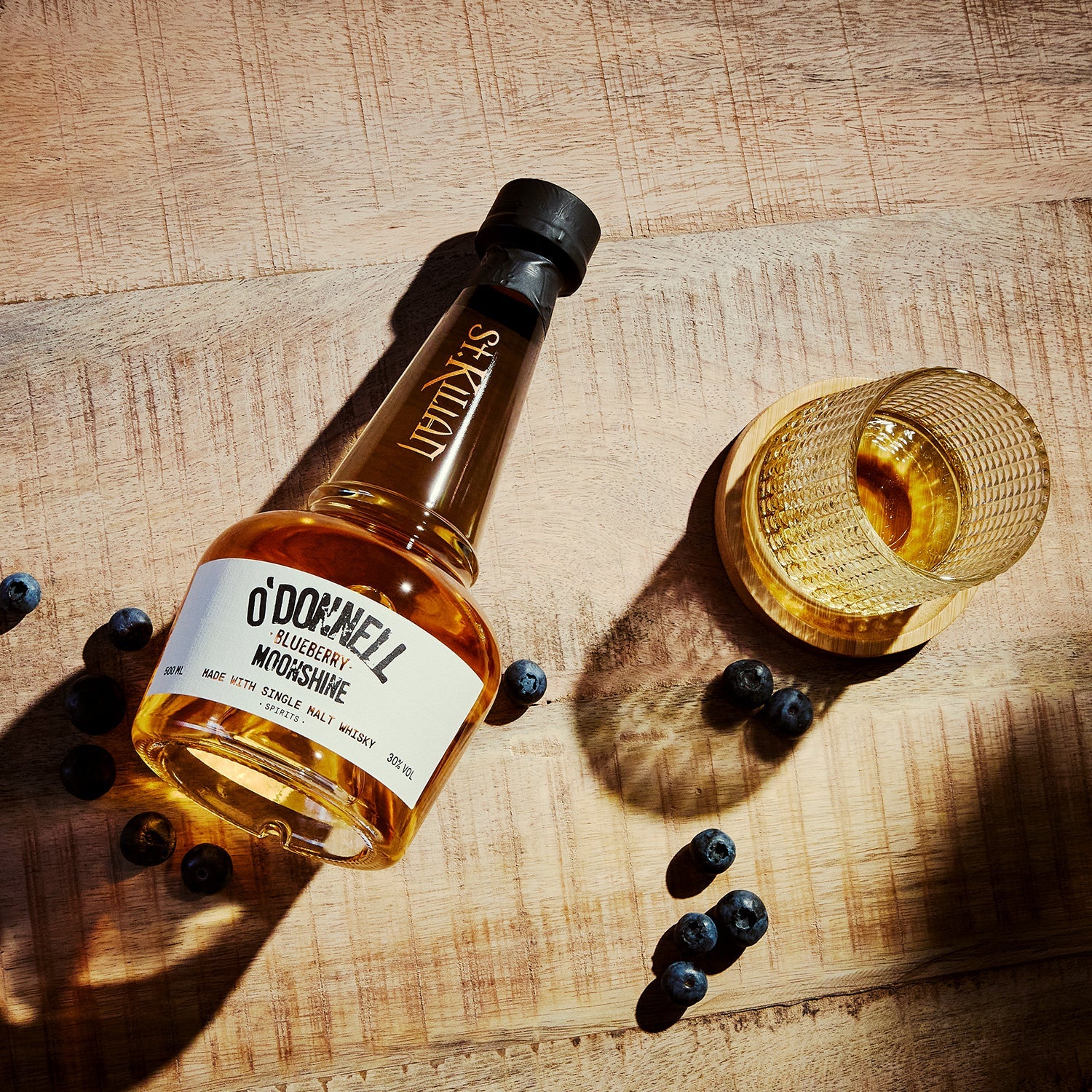 O'Donnell & St.Kilian Blueberry Moonshine Flasche umgeben von Blaubeeren
